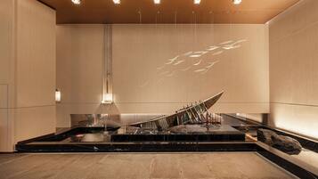 A modern interior with a central water feature, a marble countertop, and a minimalist design.