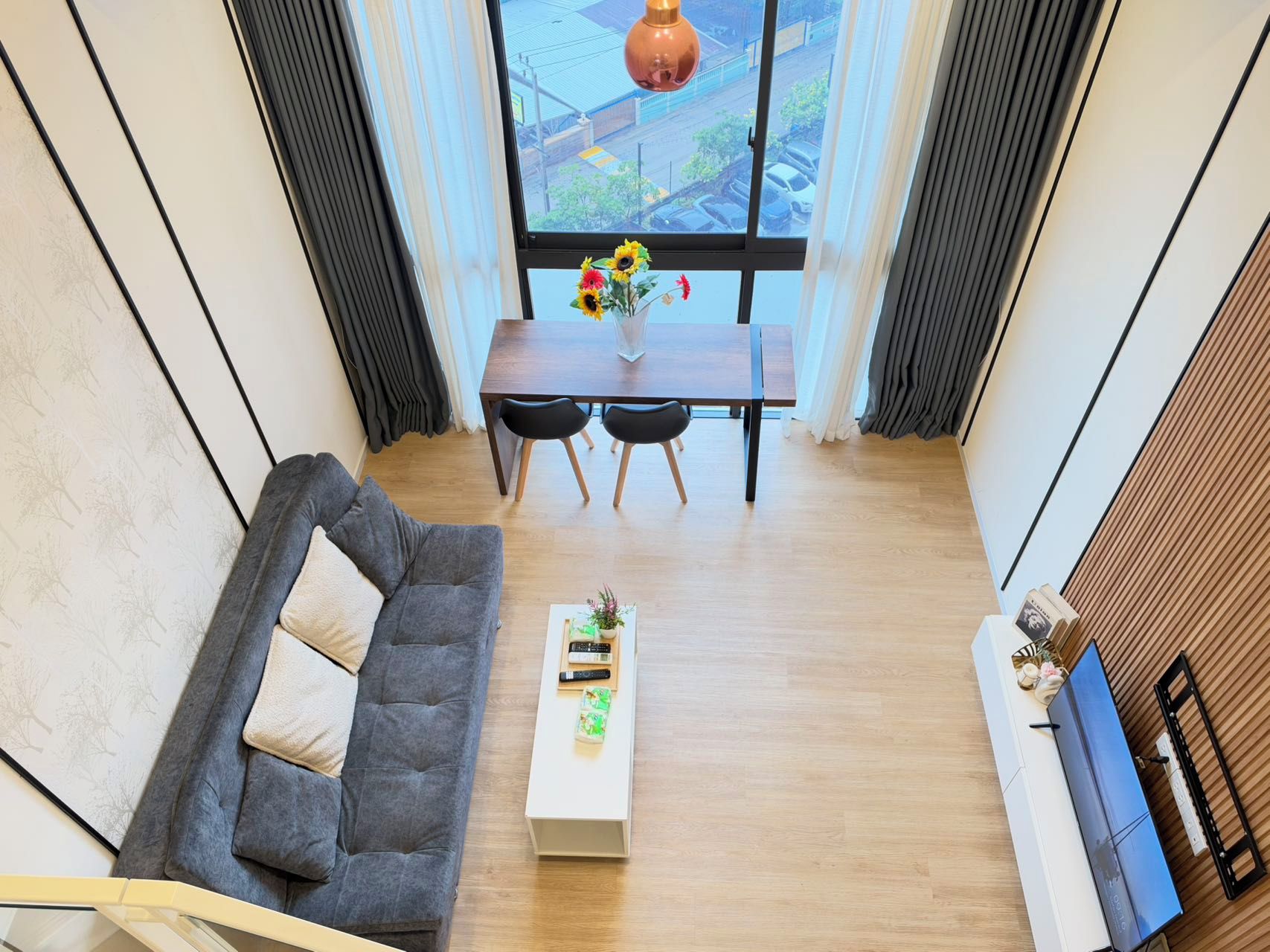 Un salon moderne comprenant un canapé, une table basse et un coin repas avec une table et des chaises.