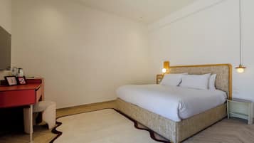 A bedroom with a bed, a desk, a chair, and a nightstand.