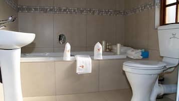 Un bagno con vasca, servizi igienici e lavabo.