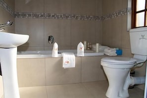A bathroom with a bathtub, toilet, and sink. - Classique  Grace Boutique Hotel and Spa (Morningside Manor)