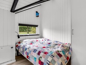 Un dormitorio con cama, ventana y radiador.