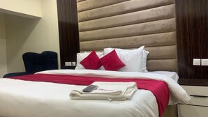 A hotel room with a bed, a chair, and a nightstand. - Asabana Suites and Hotels Enugu (Enugu)