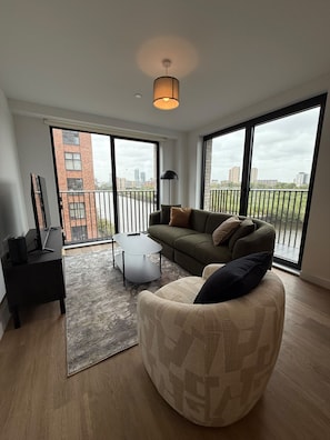 A modern living room with a sofa, armchair, and a small table.