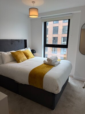 Una habitación de hotel con cama, ventana y vista a un edificio.