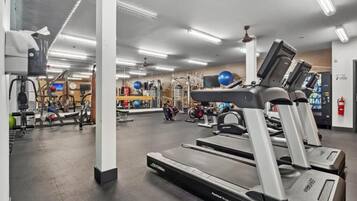 Ein Fitnessstudio mit Laufbändern, Übungsbällen und Krafttrainingsgeräten.