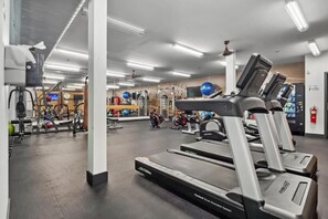 Ein Fitnessstudio mit Laufbändern, Übungsbällen und Krafttrainingsgeräten.