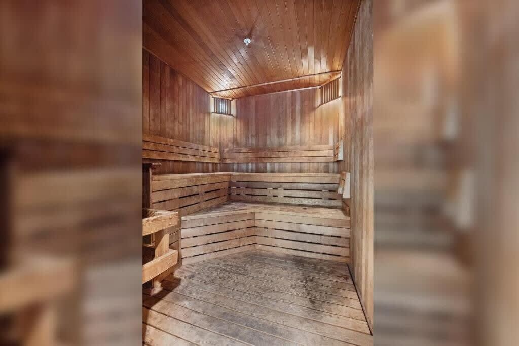 Una sauna con bancos de madera y suelo inclinado, diseñada para la relajación.