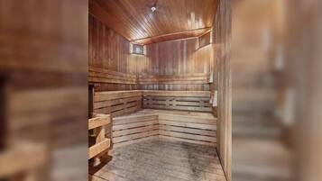 Una sauna con bancos de madera y suelo inclinado, diseñada para la relajación.