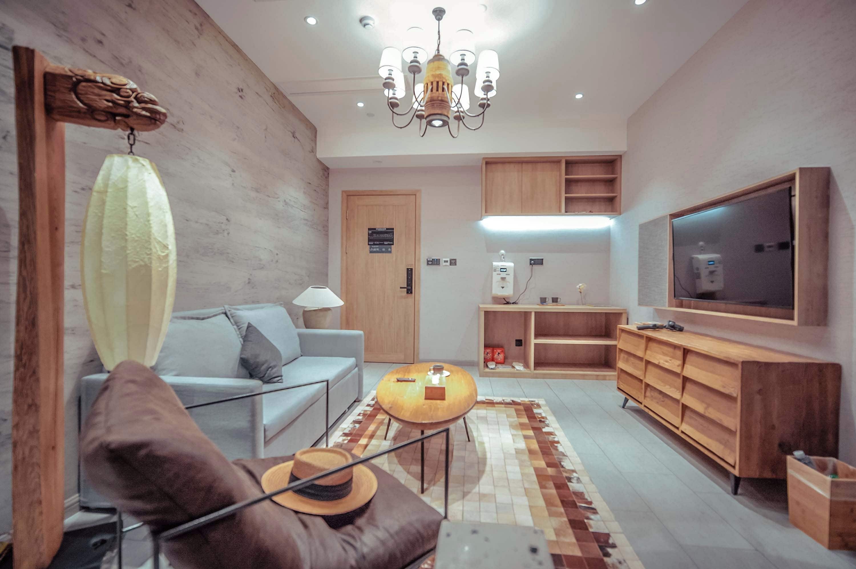 Un salon moderne avec un canapé, une table basse, un téléviseur et des meubles en bois.