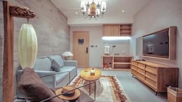 Un salon moderne avec un canapé, une table basse, un téléviseur et des meubles en bois.