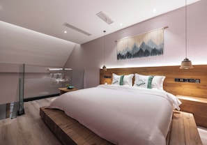 A modern bedroom with a large bed, a wooden headboard, and a glass partition.