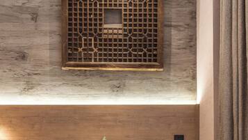 Una sala de estar moderna con un banco de madera, una mesita con una planta y cojines decorativos.