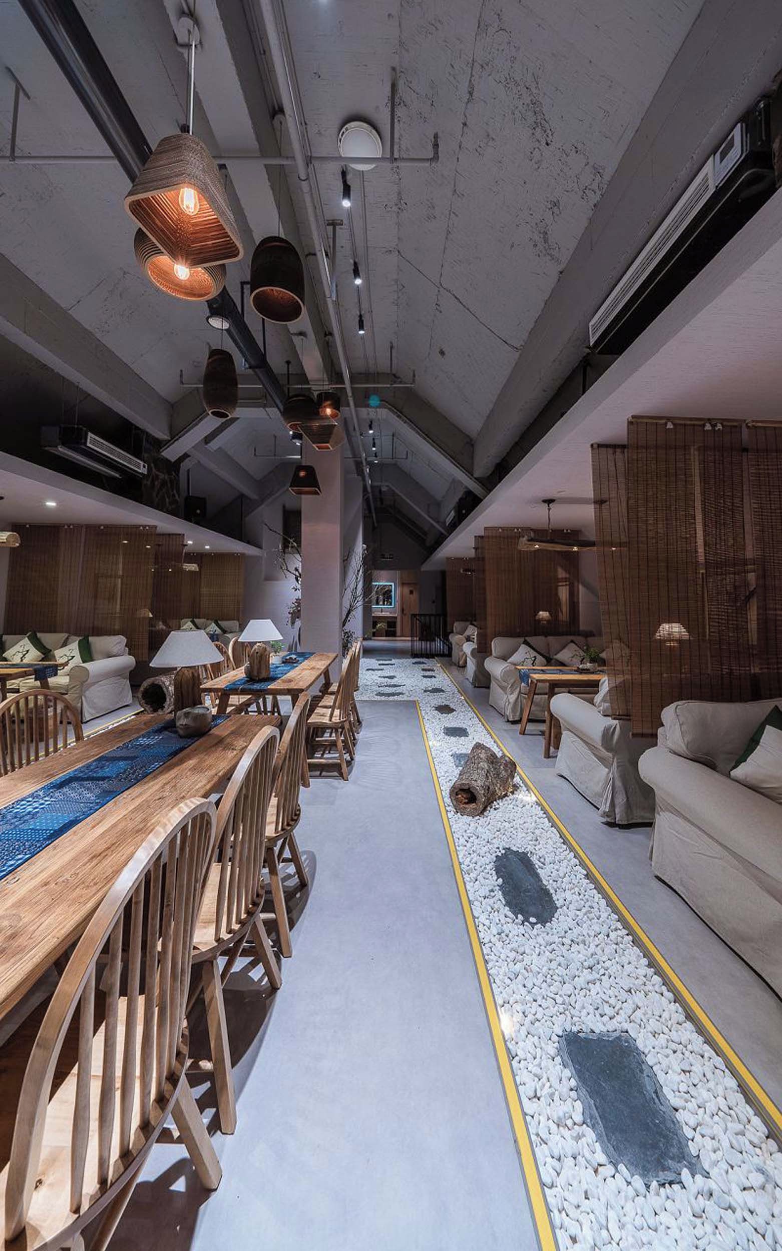 A spacious dining area with a long wooden table and chairs, a central walkway, and seating on both sides.