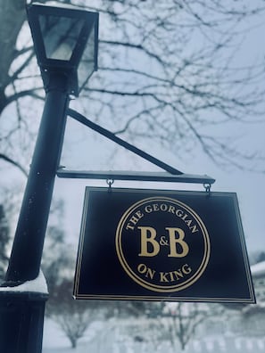 Een bordje met 'The Georgian B&B on King' hangt aan een lantaarnpaal.