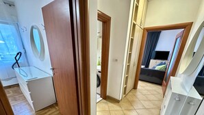 A hallway leading to a bedroom with a bed, a TV, and a wardrobe. - Alula Apartments 3 (Herceg - Novi)