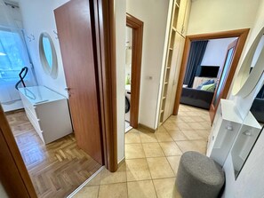 Un couloir menant à une chambre à coucher équipée d’un lit, d’un téléviseur et d’une armoire.