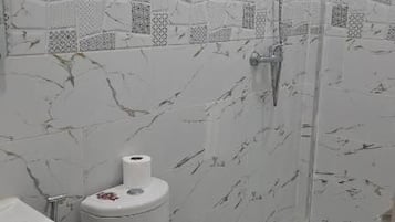 Un baño con inodoro, lavabo y ducha.