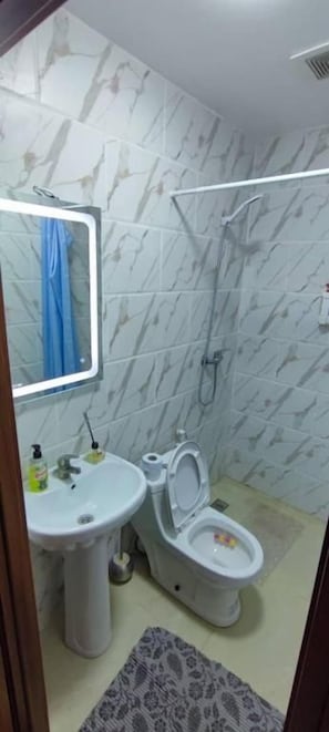 Un bany amb rentapla, vàter i plat de dutxa.