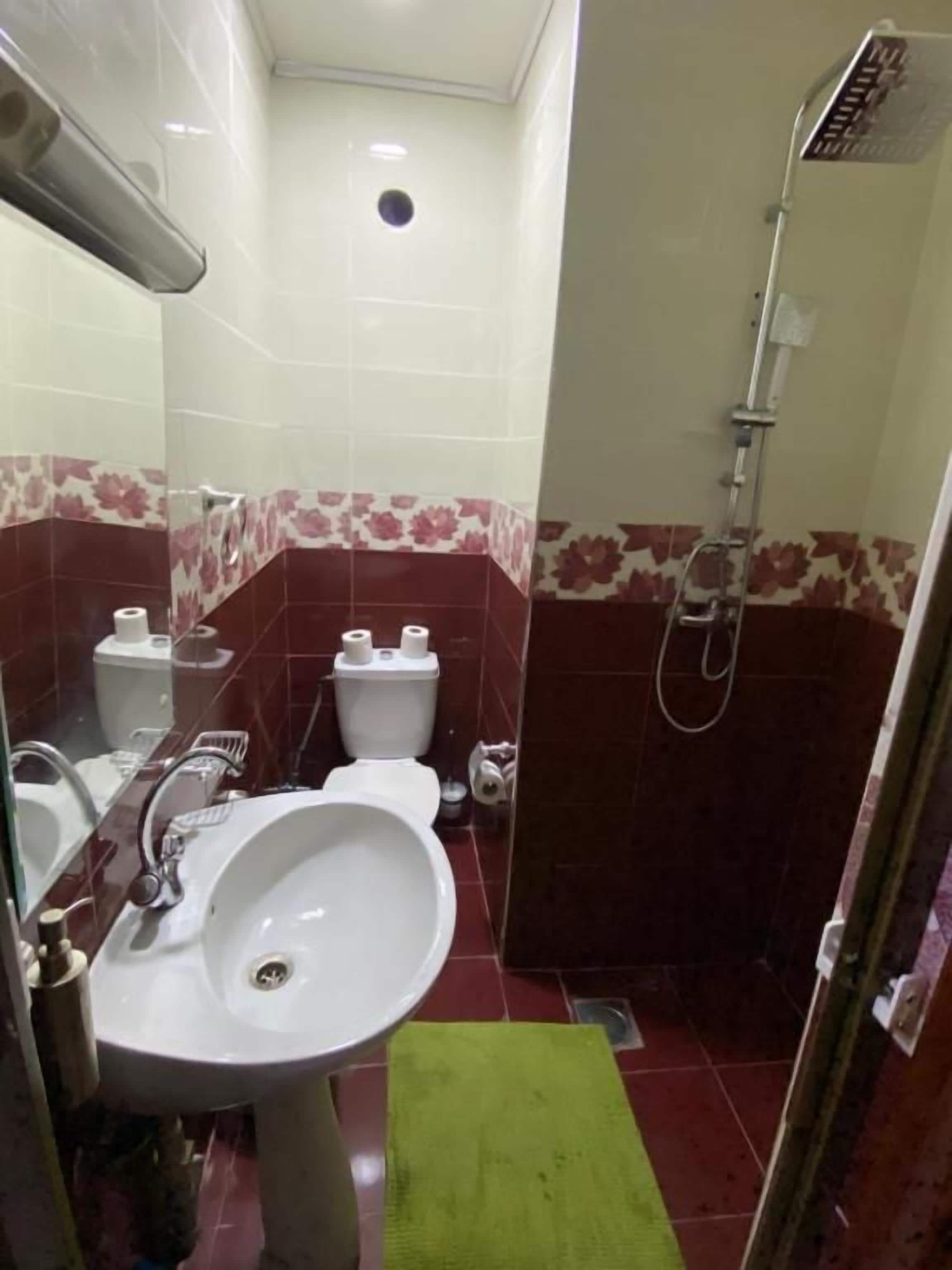 A bathroom with a sink, toilet, and shower.