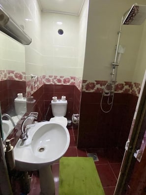 A bathroom with a sink, toilet, and shower.
