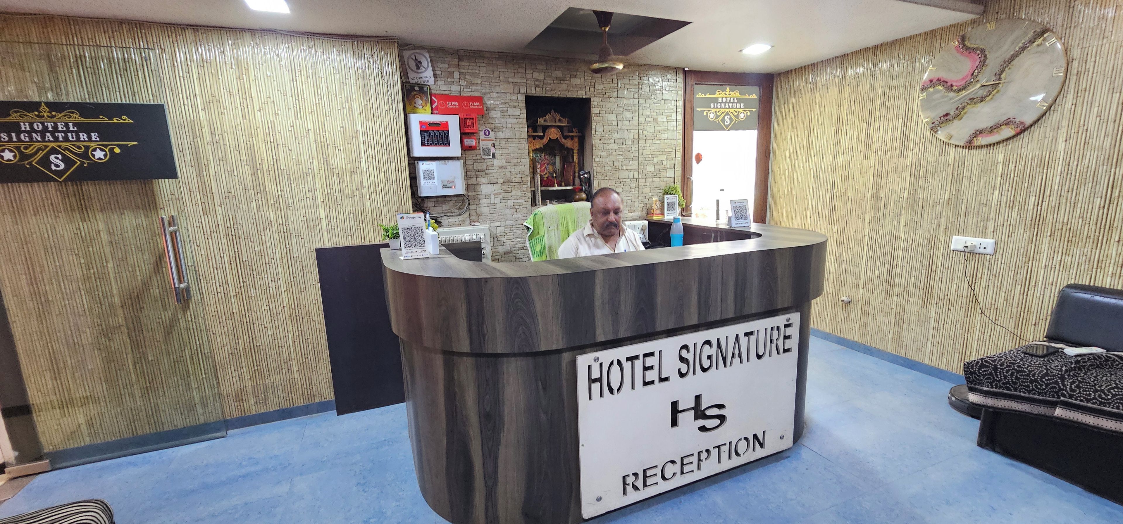 Una mesa de recepción de hotel con un cartel que dice 'HOTEL SIGNATURE RECEPTION'.
