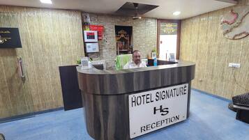 Una mesa de recepción de hotel con un cartel que dice 'HOTEL SIGNATURE RECEPTION'.