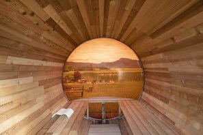 A circular wooden structure with a view of a landscape through a large opening.