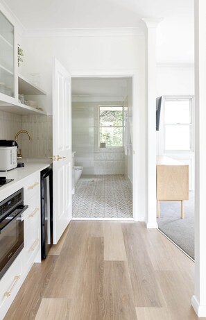 A modern kitchen with white cabinetry, a built-in oven, and a microwave. - The Wellness Farm Grateful Villa 3 (Broke)