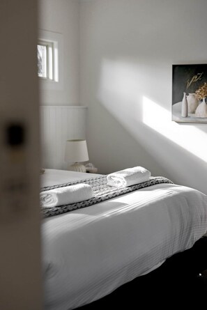A bedroom with a bed, a bedside lamp, a window, and a painting on the wall. - The Wellness Farm Mindful Villa 5 (Broke)