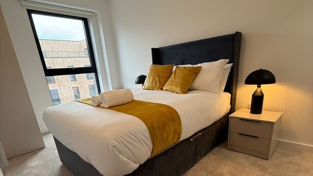 Una camera da letto moderna con un letto grande, un comodino e una finestra vista edifici.