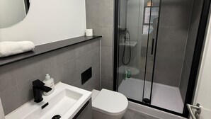 Ein modernes Badezimmer mit Dusche, Toilette und Waschbecken.