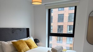 Ein Hotelzimmer mit einem Bett, einem Fenster und Blick auf ein Gebäude.