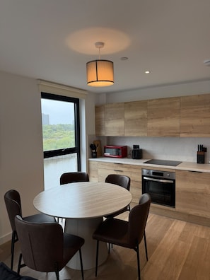 Une cuisine moderne avec des meubles en bois, une table à manger ronde et des chaises.