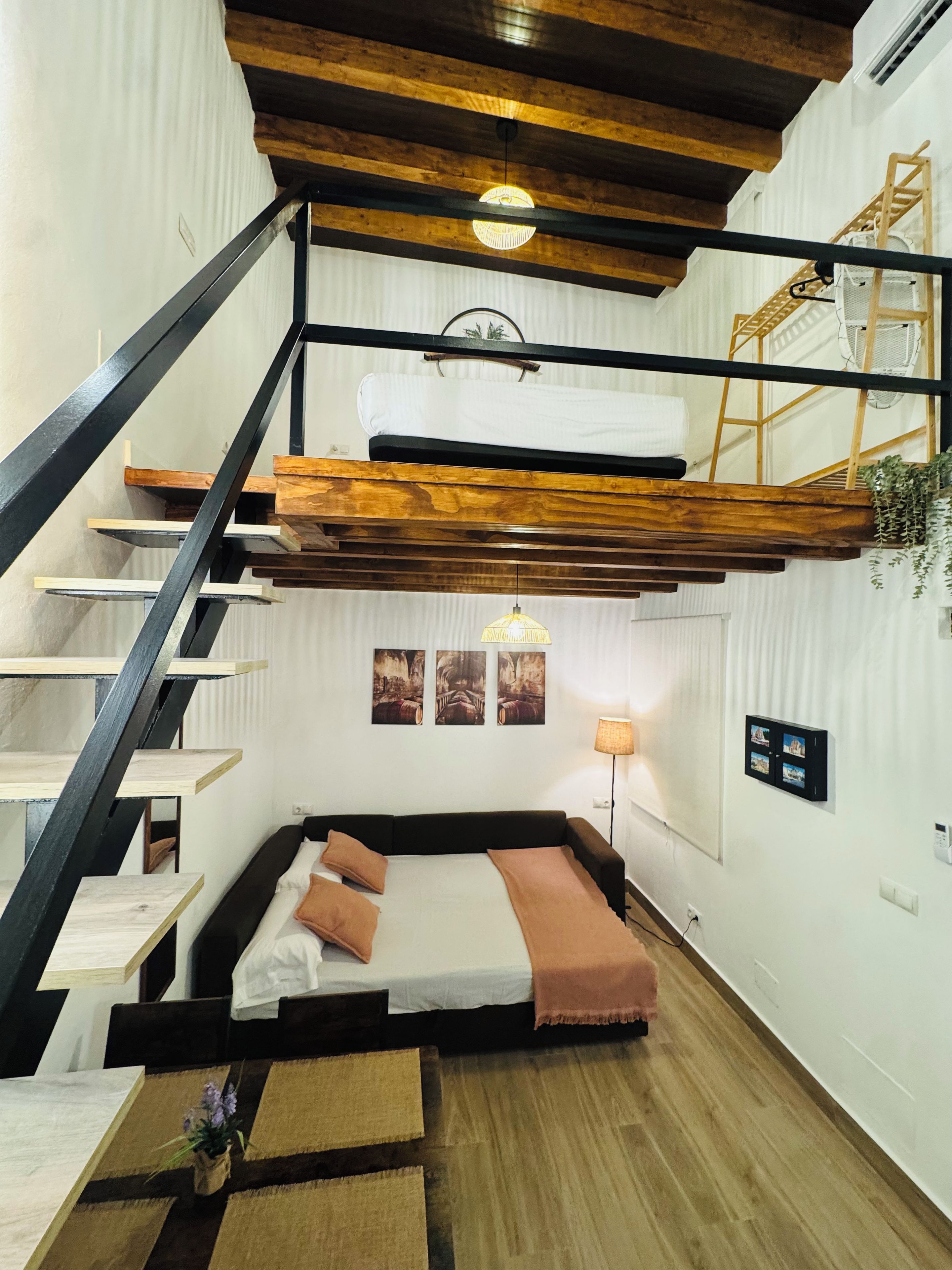 Un dormitorio estilo loft con una cama litera, una escalera de madera y un nivel entre piso.