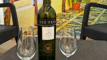 Una botella de vino Tio Pepe y dos copas de vino vacías sobre una mesa.