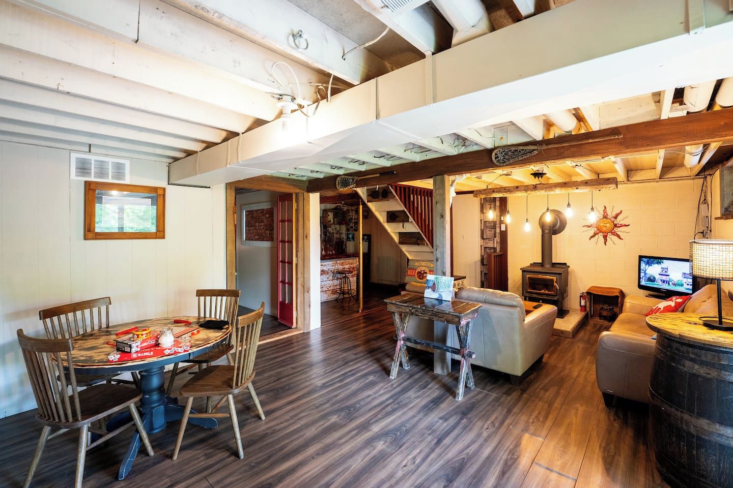 Un interior rústico con zona de comedor, sofá, televisión y chimenea.