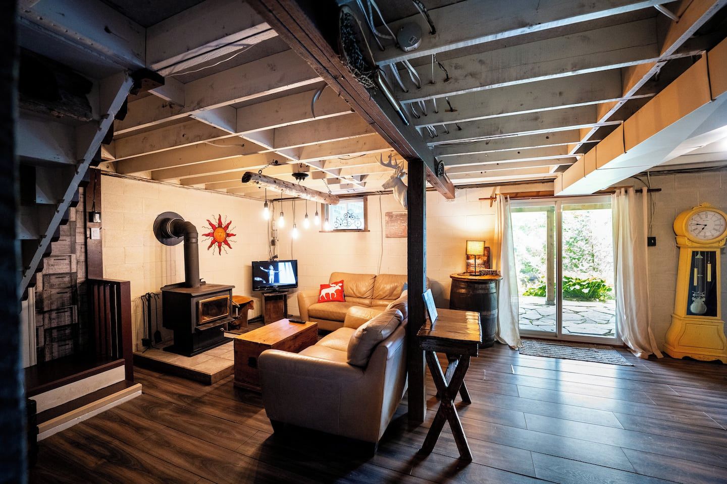 Una sala de estar acogedora con chimenea, un sofá, un televisor y un reloj.