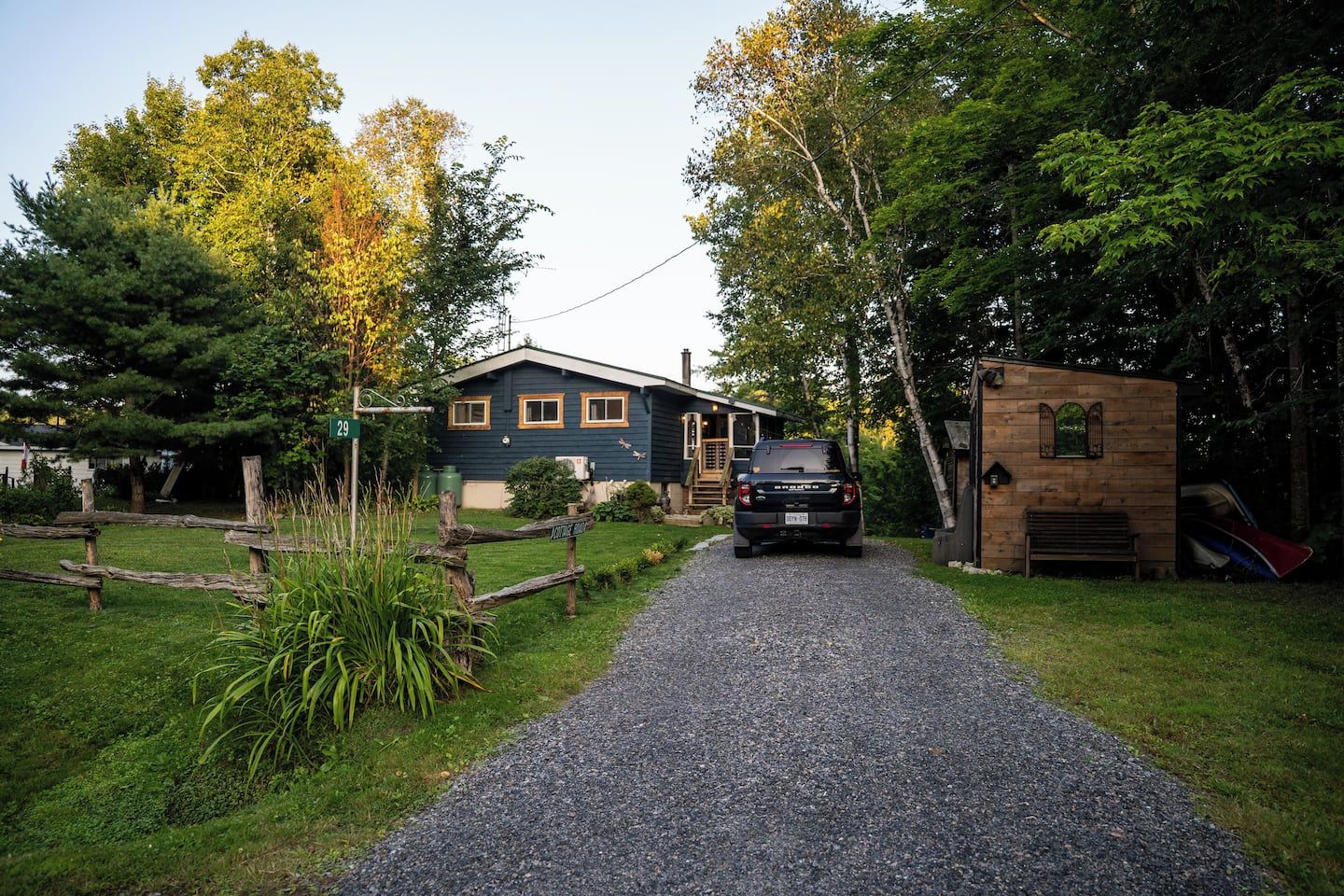 Ein Schotterweg führt zu einem Haus, vor dem ein Auto geparkt ist.