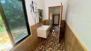 Une salle de bain avec une douche, un lavabo et un miroir.