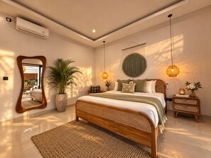 A modern bedroom with a large bed, bedside tables, a mirror, and a potted plant. - Private Pool Villa, Central Canggu (Badung)