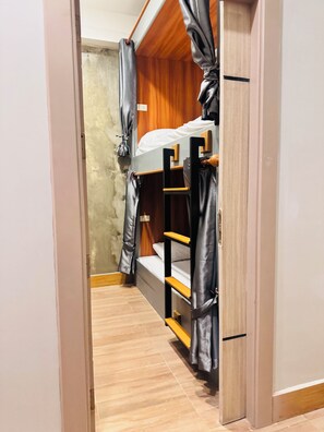 A narrow hallway leading to a room with a bunk bed, wooden walls, and a curtain. - Lao Smart Box Hostel (Vientiane)