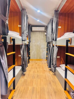 A corridor with bunk beds, wooden flooring, and an air conditioning unit on the wall. - Lao Smart Box Hostel (Vientiane)