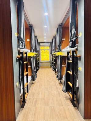 A corridor with bunk beds, wooden walls, and a tiled floor. - Lao Smart Box Hostel (Vientiane)