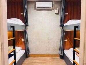 A room with two bunk beds, an air conditioning unit, and a curtain. - Lao Smart Box Hostel (Vientiane)
