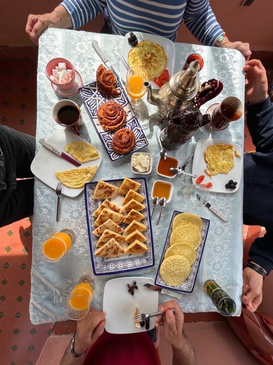 Ein Tisch mit verschiedenen Frühstücksartikeln, darunter Gebäck, Eier und Getränke.