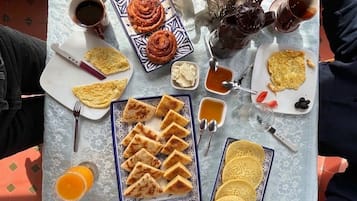 Ett bord med olika sorters frukostmat, inklusive bakverk, ägg och drycker.