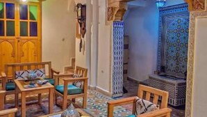A traditional interior with wooden furniture and patterned carpets. - Dar roeya (Fes)