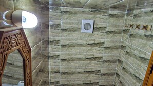 A bathroom with a toilet, sink, and mirror. - Dar roeya (Fes)
