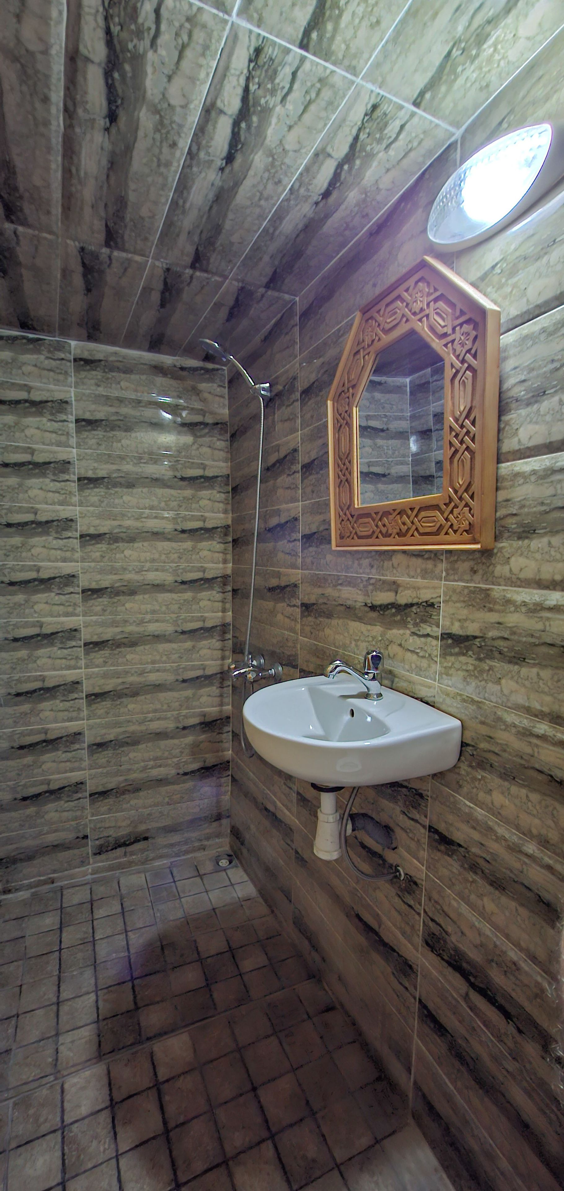 A bathroom with a shower, a sink, and a mirror.